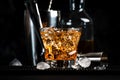 Godfather alcoholic cocktail with scotch whiskey, amaretto liqueur and ice. Black bar counter background, steel bar tools, copy Royalty Free Stock Photo