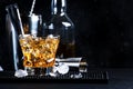 Godfather alcoholic cocktail with scotch whiskey, amaretto liqueur and ice. Black bar counter background, steel bar tools, copy Royalty Free Stock Photo