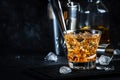 Godfather alcoholic cocktail with scotch whiskey, amaretto liqueur and ice. Black bar counter background, steel bar tools, copy Royalty Free Stock Photo