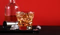 Godfather cocktail with scotch whiskey, almond amaretto liqueur and ice cubes.. Black and red background, steel bar tools Royalty Free Stock Photo