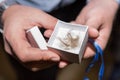 The Godfather holds little box with cut hair during the Christening Baptism ceremony at the church