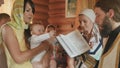 The godmother blows on her godson during the priest is reciting the prayer