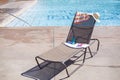 Lounge chair by a swimming pool with sunscreen and a towel Royalty Free Stock Photo
