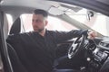 Going back. Side view of man sitting in the modern car with black interior