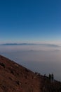 Hikers Descending a Volcanic Mountain into a Sea of Mist Royalty Free Stock Photo
