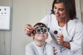 This is going fun. Doctor tuning the phoropter to to determine visual acuity of the little boy Royalty Free Stock Photo