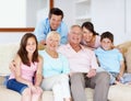 Going through life together - Family Support. Three generations of family sitting together affectionately on the lounge Royalty Free Stock Photo
