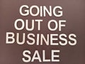 Going out of business sale sign on a brown background Royalty Free Stock Photo