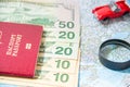 Going to travel. Passport, magnifier, red toy car and money on map. Save money on travel, planning for budget concept. Royalty Free Stock Photo