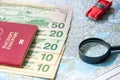 Going to travel. Passport, magnifier, red toy car and money on map. Save money on travel, planning for budget concept. Royalty Free Stock Photo