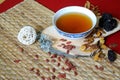 Goji berries, chinese dates, astragalus root pieces with a bowl of herb tea on red background. Side view. Royalty Free Stock Photo