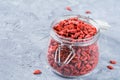 Goji berries in a jar on textured background