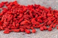 Goji berries scattered on gray stone background. Selective focus