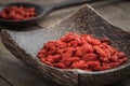 Goji berries on wooden plate and spoon Royalty Free Stock Photo