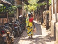 Gokarna, India - February 21, 2023 - Morning in Gokarna, rear view of Indian woman in sari walking down the street