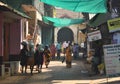 GOKARNA KARNATAKA INDIA - JANUARY 29 2016: Indian woman in yellow traditional indian sari walking down the crowded street in