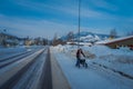 GOL, NORWAR, APRIL, 02, 2018: Unidentified woman walking using a cart support, wearing warm clothes in the streets Royalty Free Stock Photo