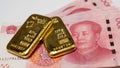 Gold bullion bars and Chinese Yuan renminbi banknotes, paper money and currency. Bank of China reserves