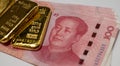 Gold bullion bars and Chinese Yuan renminbi banknotes, paper money and currency. Bank of China reserves