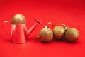 Gold balls and decorative watering can on a red background