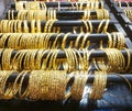 Gold Bangles are displayed with black wooden racks.