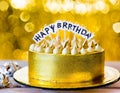 A gold banner with a happy birthday message decorates the birthday cake