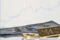 Gold bar, coins and a hundred-dollar bills on the background of the growth chart Royalty Free Stock Photo