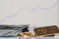 Gold bar, coins and a one hundred euro banknotes on the background of the growth chart. Royalty Free Stock Photo