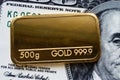 Gold bar weighing 500 grams 999.9, fineness against a blurred background of dollar