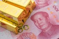 Gold bars on Chinese yuan bill banknotes background. Concept of gold future trading, online asset commodity trading or buy gold