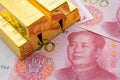 Gold bars on Chinese yuan bill banknotes background. Concept of gold future trading, online asset commodity trading