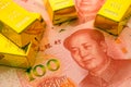 Gold bars on Chinese yuan bill banknotes background. Concept of gold future trading, online asset commodity trading or buy gold