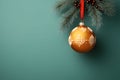 Gold bauble hanging on a Christmas tree branch on the right. Green background. Side view.Christmas banner with space for your own Royalty Free Stock Photo