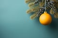 Gold bauble hanging on a Christmas tree branch on the right. Green background. Side view.Christmas banner with space for your own Royalty Free Stock Photo