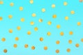 Gold big confetti sprinkles on pastel blue backdrop. Festive holiday background. for your projects. Celebration concept. Christmas