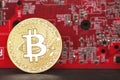 Gold bitcoin against the background of the motherboard