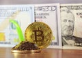 Gold bitcoin, in the background, dollars, decreasing chart, close-up Royalty Free Stock Photo