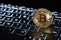 Gold Bitcoin on blue backlit keyboard, crypto currency coin, digital technology concept