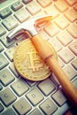 Gold Bitcoin Coin with a Silver Hammer on a Keyboard cryptocurrency digital currency Royalty Free Stock Photo