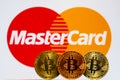Gold Bitcoin coins with the MasterCard logo on background Royalty Free Stock Photo
