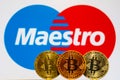 Gold Bitcoin coins with the maestro logo on background Royalty Free Stock Photo