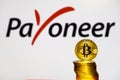 Gold Bitcoin coins with the Payoneer logo