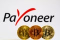 Gold Bitcoin coins with the Payoneer logo