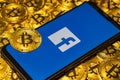 Gold Bitcoin coins pile with the Facebook logo