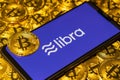 Gold Bitcoin Coins pile with the Facebook Libra Crypto Coin logo