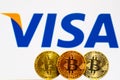 Gold Bitcoin coins with the Visa logo