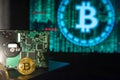 Gold Bitcoin with hard disk, green binary screen in the background