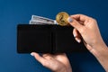 Gold bitcoin and one hundred dollar bills in a leather wallet held by a girl Royalty Free Stock Photo