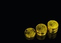 Gold Bitcoin stack on black background.