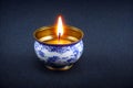 Gold and blue patterned incense bowl, candlelight, black background with Generative AI